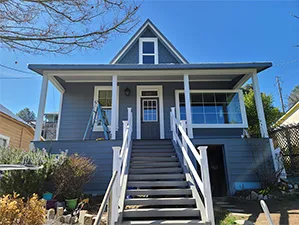 Front view of a modern two-story home with freshly installed James Hardie™ HardiePlank® siding in Arctic White, featuring clean trim and new windows.
