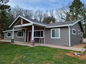 Front view of a modern two-story home with freshly installed James Hardie™ HardiePlank® siding in Arctic White, featuring clean trim and new windows.