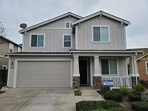 Front view of a modern two-story home with freshly installed James Hardie™ HardiePlank® siding in Arctic White, featuring clean trim and new windows.