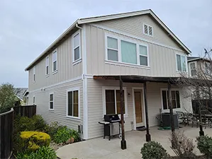 Front view of a modern two-story home with freshly installed James Hardie™ HardiePlank® siding in Arctic White, featuring clean trim and new windows.