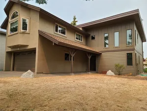 Front view of a modern two-story home with freshly installed James Hardie™ HardiePlank® siding in Arctic White, featuring clean trim and new windows.